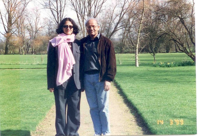 Sanjaya Lall and his wife Rani on a path across parkland in early spring
